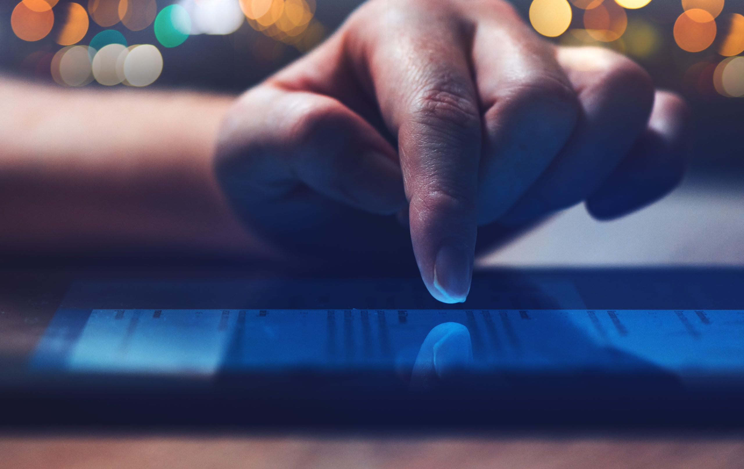 Woman reading online news on digital tablet, close up of hands using device.